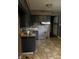 Functional kitchen featuring dark cabinetry, a tiled backsplash, and tiled floor, ready for essential meal preparation at 3320 E 26Th St, Indianapolis, IN 46218