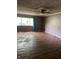 Spacious living room features hardwood floors, large window and ceiling fan, ready for personalized updates and comfortable living at 3320 E 26Th St, Indianapolis, IN 46218
