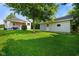 View of the expansive backyard featuring lush lawn, mature trees and a detached garage at 3329 Main St, Anderson, IN 46013
