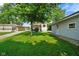 A spacious backyard with a large tree provides shade for the house and detached garage at 3329 Main St, Anderson, IN 46013