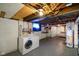 Spacious basement area featuring laundry setup, open ceilings, with bedroom area in the back at 3329 Main St, Anderson, IN 46013