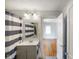 Bathroom with gray and white striped shower curtain, toilet and view to the bedroom at 3329 Main St, Anderson, IN 46013