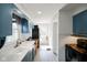 Galley kitchen featuring blue cabinets, white countertops, stainless appliances, and wood flooring at 3329 Main St, Anderson, IN 46013