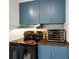 Corner of kitchen featuring black oven and blue cabinets and stainless steel range hood at 3329 Main St, Anderson, IN 46013