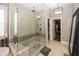 Modern bathroom featuring a glass-enclosed shower with tile surround and a view into the walk-in closet at 3429 Woodham Pl, Carmel, IN 46033