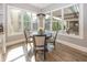 Sun-filled breakfast nook with a round table and large windows overlooking the backyard at 3429 Woodham Pl, Carmel, IN 46033