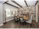 Elegant dining room featuring exposed beams, stone accent wall, and unique light fixtures at 3429 Woodham Pl, Carmel, IN 46033
