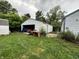 Detached garage containing car and other items; overgrown greenery in yard at 3440 Brewer Dr, Indianapolis, IN 46222