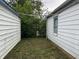 Narrow overgrown yard between detached garage and house at 3440 Brewer Dr, Indianapolis, IN 46222
