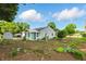 Landscaped backyard with a garden area, mature trees, and a sunroom addition on the house at 409 Hanley St, Plainfield, IN 46168