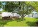 Backyard featuring a wooden deck, mature trees, well-kept lawn, and home exterior at 409 Hanley St, Plainfield, IN 46168