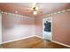 Spacious bedroom with hardwood floors, a ceiling fan, and warm neutral wall color at 409 Hanley St, Plainfield, IN 46168