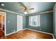 Hardwood bedroom featuring a ceiling fan, a window, and an adjoining hallway at 409 Hanley St, Plainfield, IN 46168