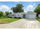 A charming single-story home with light blue siding, attached garage, and a well-maintained lawn at 409 Hanley St, Plainfield, IN 46168
