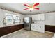 White kitchen featuring stainless steel appliances, bright lighting, brick accent wall, and vintage wallpaper border at 409 Hanley St, Plainfield, IN 46168