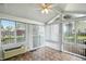 Bright sun room with tile floors, many windows, and a white ceiling fan at 409 Hanley St, Plainfield, IN 46168
