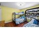 Bedroom with hardwood floors and bunk beds with yellow walls at 4126 E Rembrandt Dr, Martinsville, IN 46151
