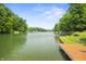Scenic view of the serene lake surrounded by lush greenery and mature trees on a clear day at 4126 E Rembrandt Dr, Martinsville, IN 46151
