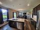 Modern kitchen with island, stainless steel appliances, dark wood cabinets, and open layout to the living area at 4216 Lauder Rd, Bargersville, IN 46106