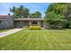 Inviting single-story home with stone and wood facade, lush lawn, and well-maintained landscaping at 4742 Kingsley Dr, Indianapolis, IN 46205