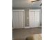 Bedroom with neutral carpeting and two closets with white doors and white trim at 4760 Winterberry Pl, Columbus, IN 47201