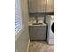 Charming laundry room sink with modern faucet and cabinets, paired with a washer and dryer at 4760 Winterberry Pl, Columbus, IN 47201