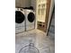 View of laundry room with modern washer and dryer, tile floor, and convenient mudroom entrance at 4760 Winterberry Pl, Columbus, IN 47201