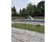 View of the in-ground pool from the weathered wood deck with a blue slide and diving board at 4760 Winterberry Pl, Columbus, IN 47201