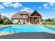 Landscaped backyard with pool, diving board, pool house, and lounge chairs offers ultimate outdoor living at 4931 Kerrington Blvd, Bargersville, IN 46106