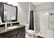 Bathroom featuring dark wood cabinetry and a granite counter plus a tiled shower with shelving at 4931 Kerrington Blvd, Bargersville, IN 46106