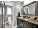 Bathroom with a stone countertop vanity and mirror, with a toilet and window view in the background at 4931 Kerrington Blvd, Bargersville, IN 46106