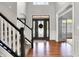Grand foyer showcasing hardwood floors, staircase with white banister, and decorative front door at 4931 Kerrington Blvd, Bargersville, IN 46106