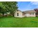 Expansive backyard view of single-story home with green grass and mature trees at 50 Crestview Dr, Greenwood, IN 46143