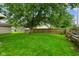 Lush backyard featuring a mature tree, a wood fence, and plenty of green grass at 50 Crestview Dr, Greenwood, IN 46143