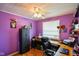 This bedroom features purple walls, hardwood floors, a ceiling fan, and built-in shelving at 50 Crestview Dr, Greenwood, IN 46143