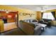 Living room features a gray sofa, an adjacent kitchen, yellow walls, and dark carpet at 50 Crestview Dr, Greenwood, IN 46143