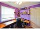 A cozy office with purple walls, built-in shelving, and a custom wood desk at 50 Crestview Dr, Greenwood, IN 46143