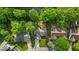 Aerial view of the home with a green lawn and deck surrounded by mature trees at 5010 Donner Ln, Indianapolis, IN 46268