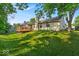 Spacious backyard with a deck, mature trees and lush green lawn at 5010 Donner Ln, Indianapolis, IN 46268