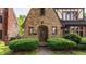 A closer view of the entryway, featuring an arched doorway, brick facade, and lush shrubbery at 5615 N Pennsylvania St, Indianapolis, IN 46220