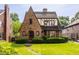 Charming Tudor-style home with brick facade, gabled roof, and well-manicured lawn and shrubbery at 5615 N Pennsylvania St, Indianapolis, IN 46220