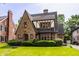 Charming Tudor-style home with brick facade, gabled roof, and well-manicured lawn and shrubbery at 5615 N Pennsylvania St, Indianapolis, IN 46220