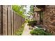 Brick home exterior featuring a private side entrance with manicured landscaping and a wooden fence at 5615 N Pennsylvania St, Indianapolis, IN 46220