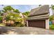 Two-car garage and driveway with mature trees and landscaping adding curb appeal to the property at 5615 N Pennsylvania St, Indianapolis, IN 46220