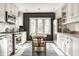 Bright kitchen featuring white cabinets, stainless steel appliances, a breakfast table, and natural light at 5615 N Pennsylvania St, Indianapolis, IN 46220