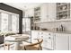 Kitchen with white cabinets, stainless steel refrigerator, breakfast nook, and adjacent window at 5615 N Pennsylvania St, Indianapolis, IN 46220