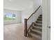 Staircase with carpeted steps, wooden handrail, and metal spindles next to hardwood flooring at 5763 Greenbrier Ct, Brownsburg, IN 46112