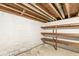 This unfinished basement features painted walls, exposed pipes, and wood shelving at 5841 N Parker Ave, Indianapolis, IN 46220