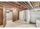 Unfinished basement featuring laundry area, concrete floor, and wood structural framing at 5841 N Parker Ave, Indianapolis, IN 46220
