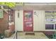 Close-up of the front door with red trim, sidelight windows, and brick column detail at 5841 N Parker Ave, Indianapolis, IN 46220